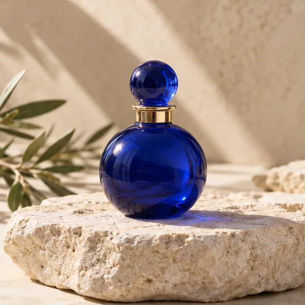 Illustrative blue perfume bottle on pale limestone