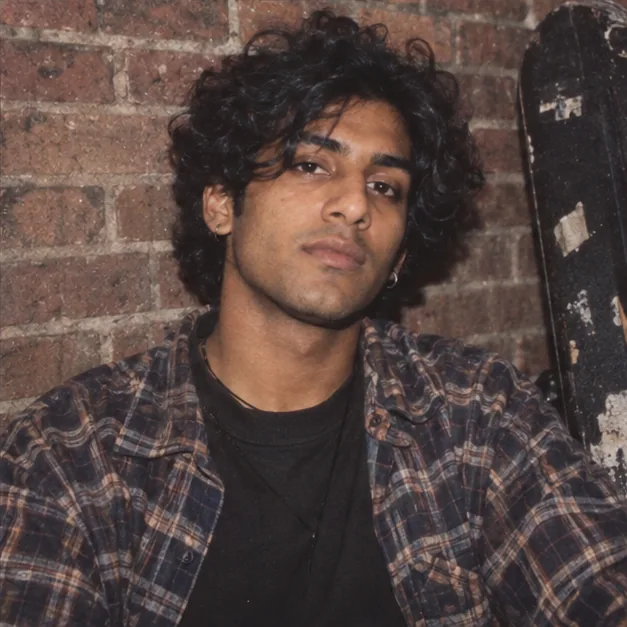 Illustrative 1990s music zine portrait of a man against brick